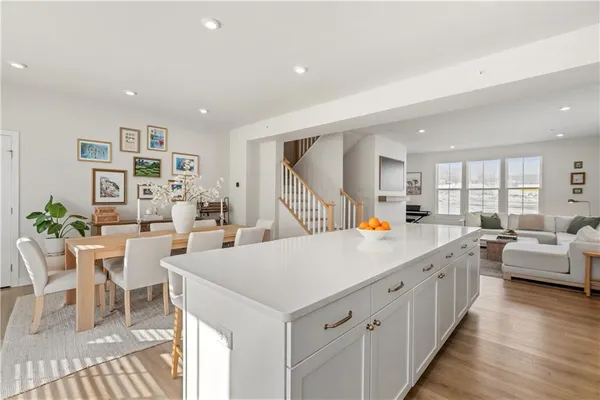 a kitchen with stainless steel appliances a dining table chairs refrigerator and sink