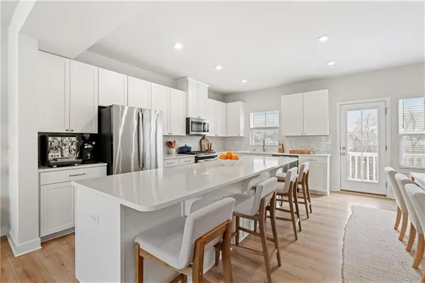a kitchen with a dining table chairs refrigerator and cabinets