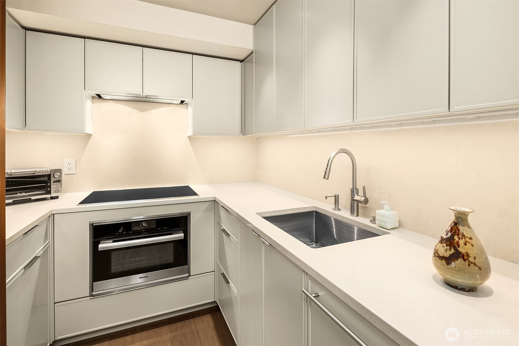 80 Vine Street, Unit 2600 Seattle, WA 98121 - Photo 28 of 40 a kitchen with white cabinets and white appliances