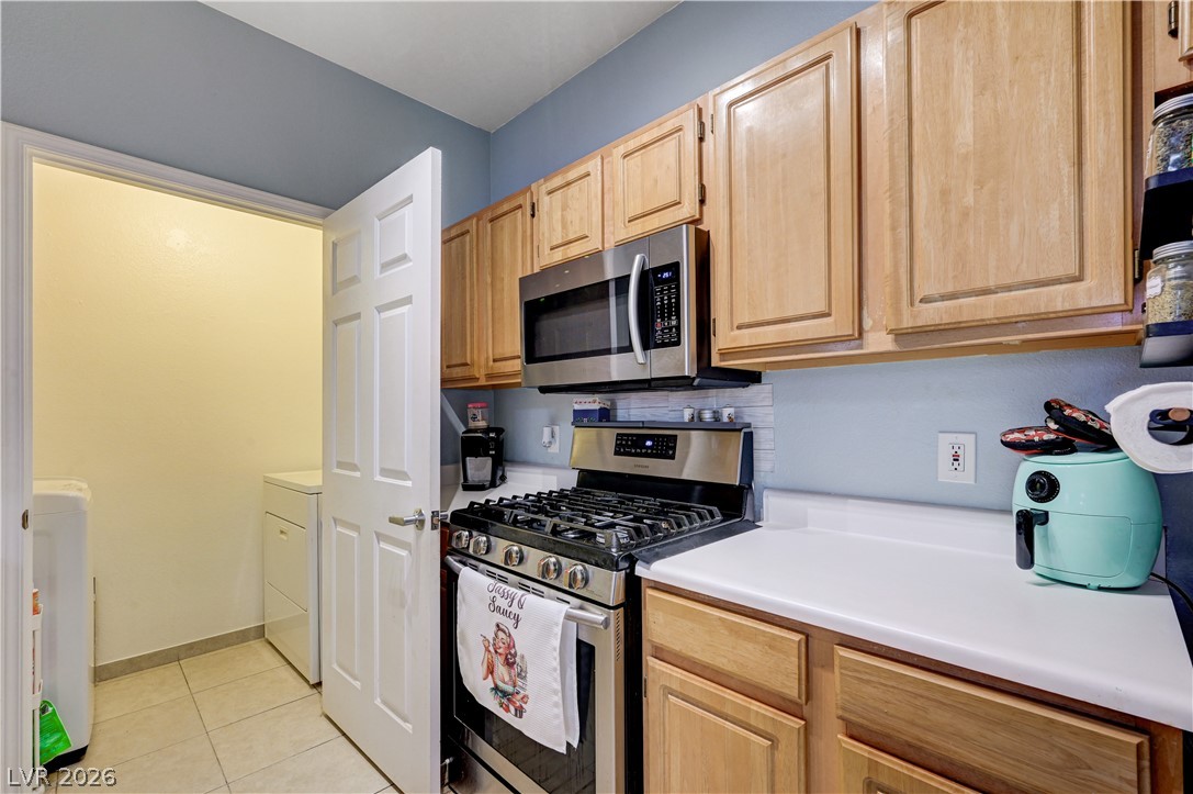8555 West Russell Road, Unit 1017 Las Vegas, NV 89113 - Photo 9 of 34 A well-appointed kitchen featuring light wood cabinetry, a stainless steel range, and a convenient pass-through to the laundry area.