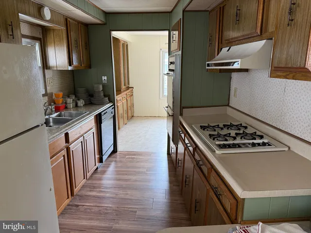 a kitchen with granite countertop a sink a counter top space stainless steel appliances and cabinets