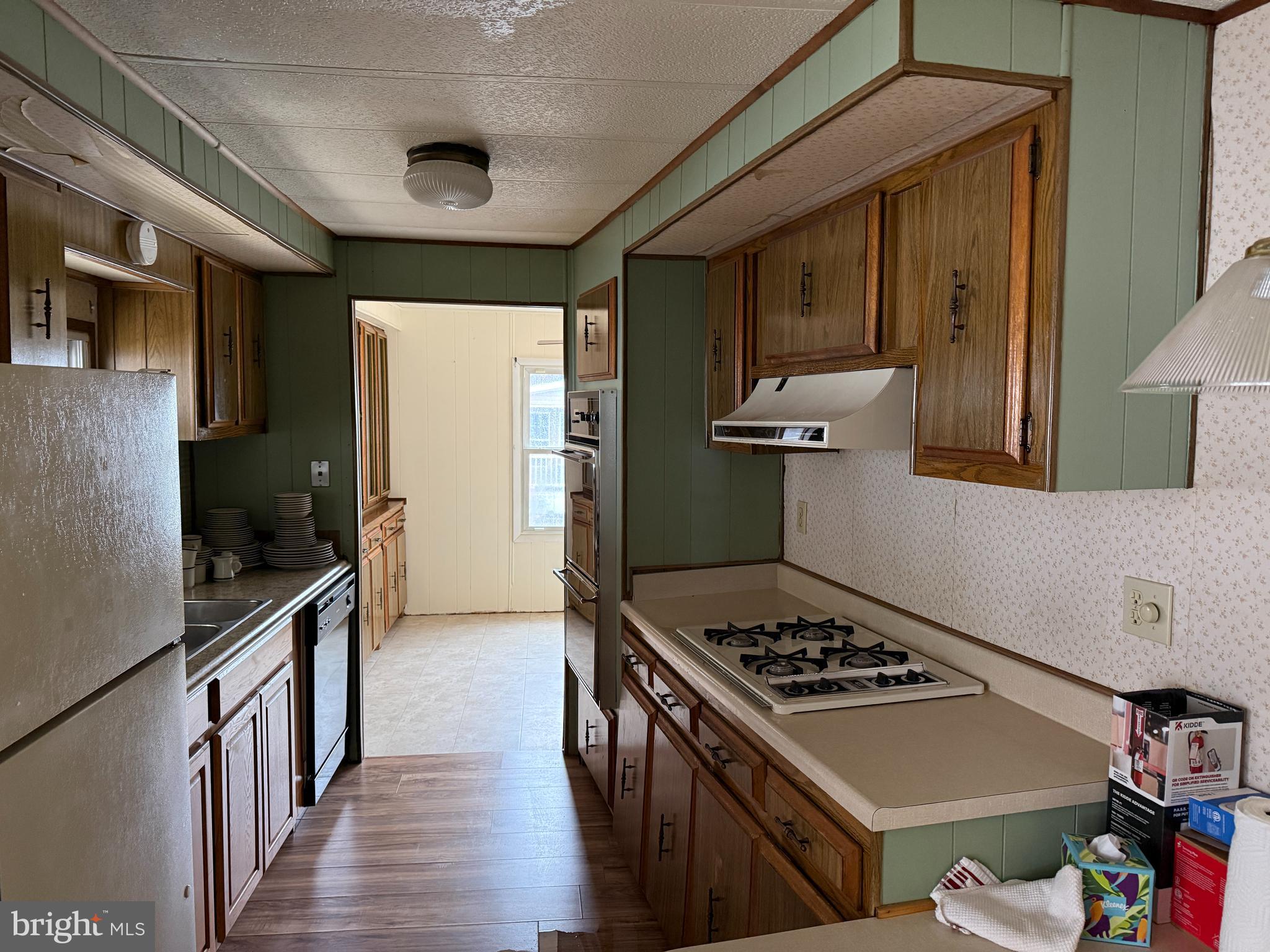 187 Rita Place Williamstown, NJ 08094 - Photo 8 of 20 a kitchen with stainless steel appliances a stove a sink a refrigerator wooden floor and cabinets