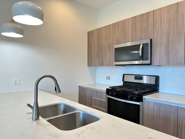 a kitchen with a sink a microwave and cabinets