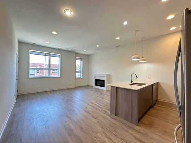 a view of a kitchen with wooden floor and electronic appliances