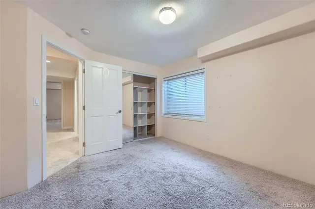 an empty room with closet and windows
