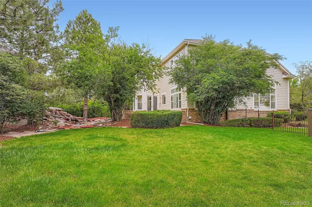 a view of a house with a big yard and large trees