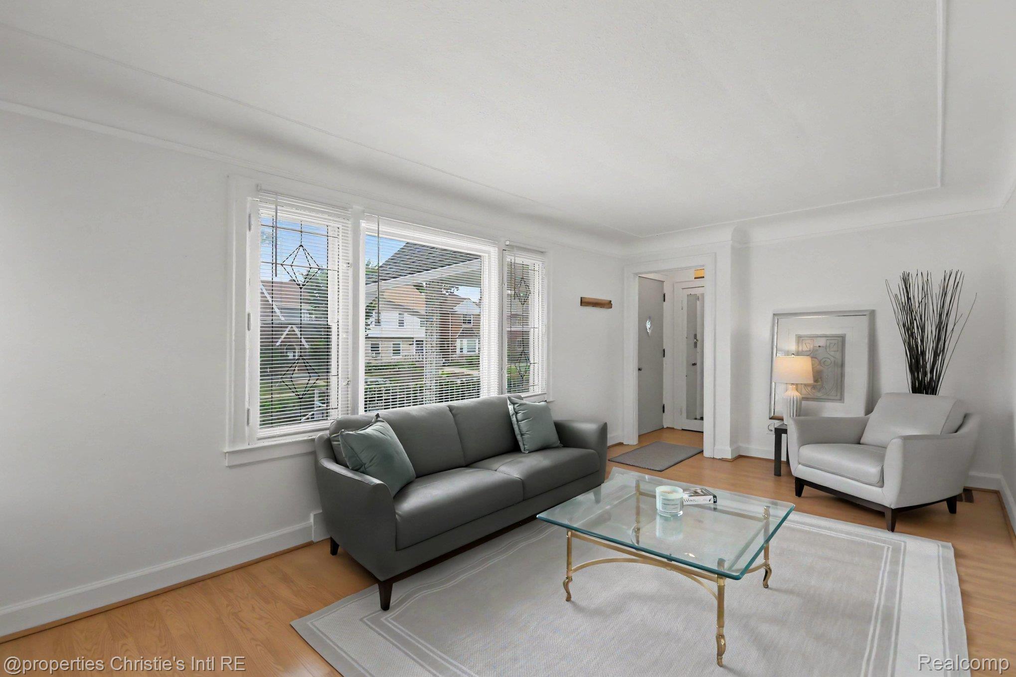18315 Prairie Street Detroit, MI 48221 - Photo 3 of 16 Bright living room featuring wide plank wood-finish flooring, white trim, and crown molding