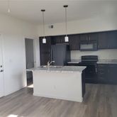 a kitchen with kitchen island stainless steel appliances a sink and refrigerator