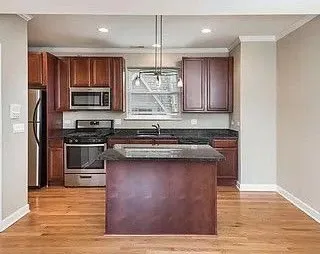 a kitchen with stainless steel appliances granite countertop a stove a sink and a refrigerator