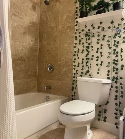a bathroom with a toilet and a shower curtain