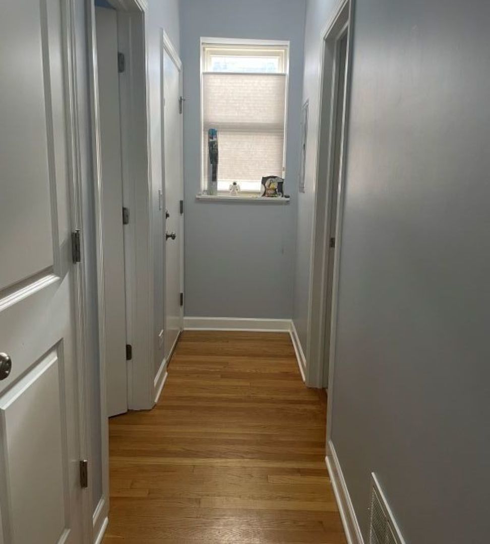 3707 North Kenneth Avenue, Unit 216 Chicago, IL 60641 - Photo 9 of 14 a view of a hallway with wooden floor and a mirror