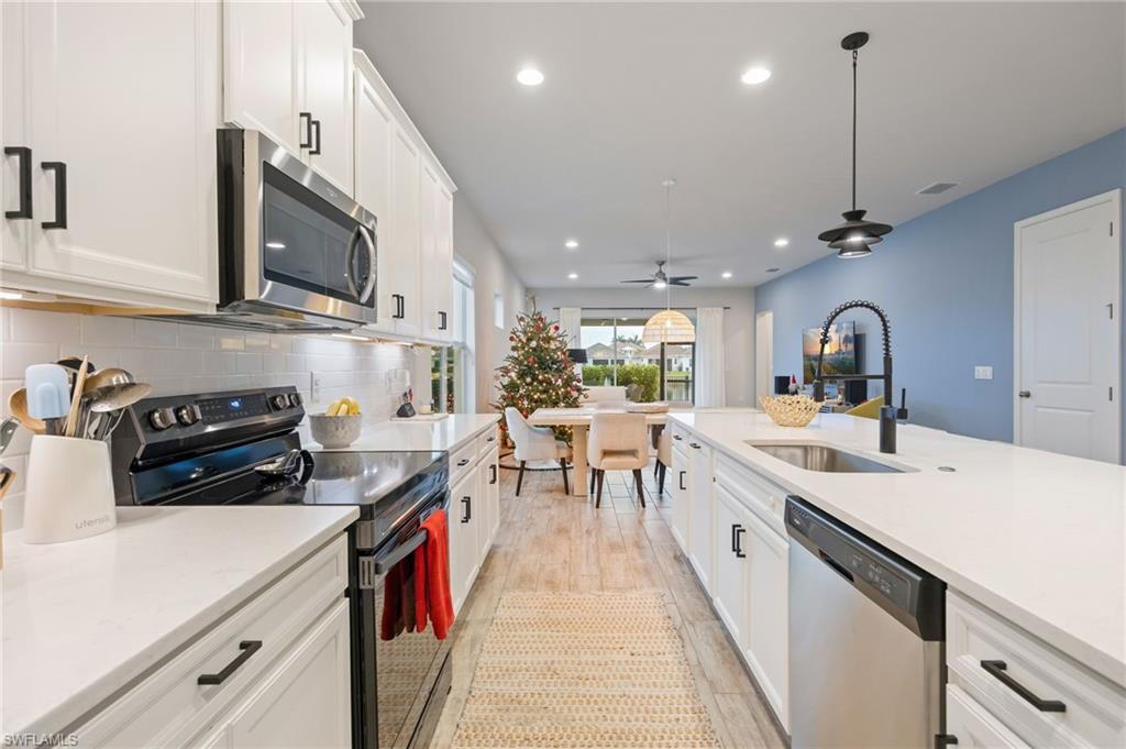 3509 Pilot Circle Naples, FL 34120 - Photo 11 of 50 a kitchen with stainless steel appliances granite countertop a sink a stove and a wooden floors