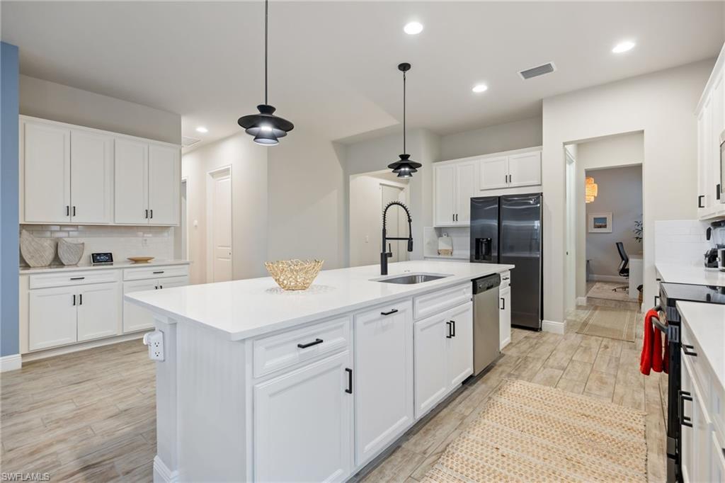 3509 Pilot Circle Naples, FL 34120 - Photo 12 of 50 a kitchen with white cabinets appliances and a chandelier