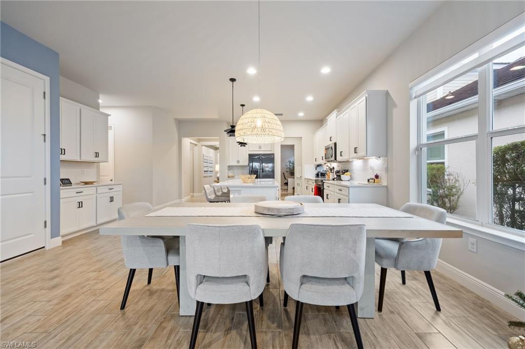 3509 Pilot Circle Naples, FL 34120 - Photo 16 of 50 a kitchen with stainless steel appliances kitchen island a table and chairs in it