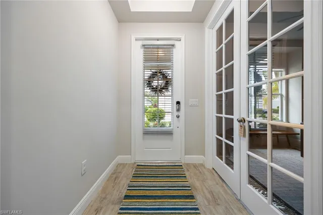 a view of a hallway with wooden floor and a window