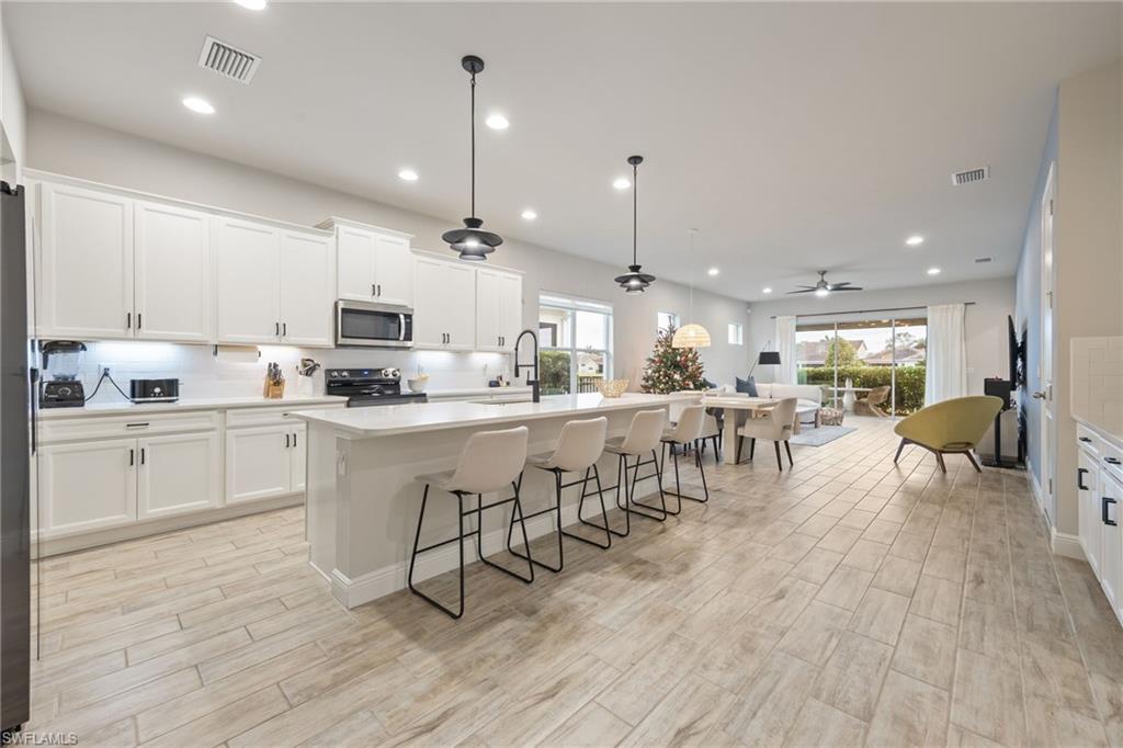 3509 Pilot Circle Naples, FL 34120 - Photo 8 of 50 a kitchen with appliances a sink a counter top space and cabinets