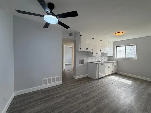 a kitchen with stainless steel appliances granite countertop a hardwood floor sink and window