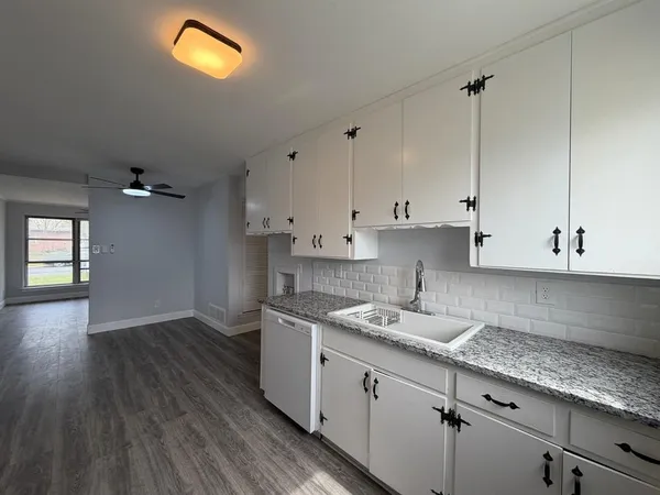 a kitchen with granite countertop a sink a cabinets and window
