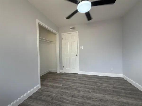 a view of an empty room with wooden floor