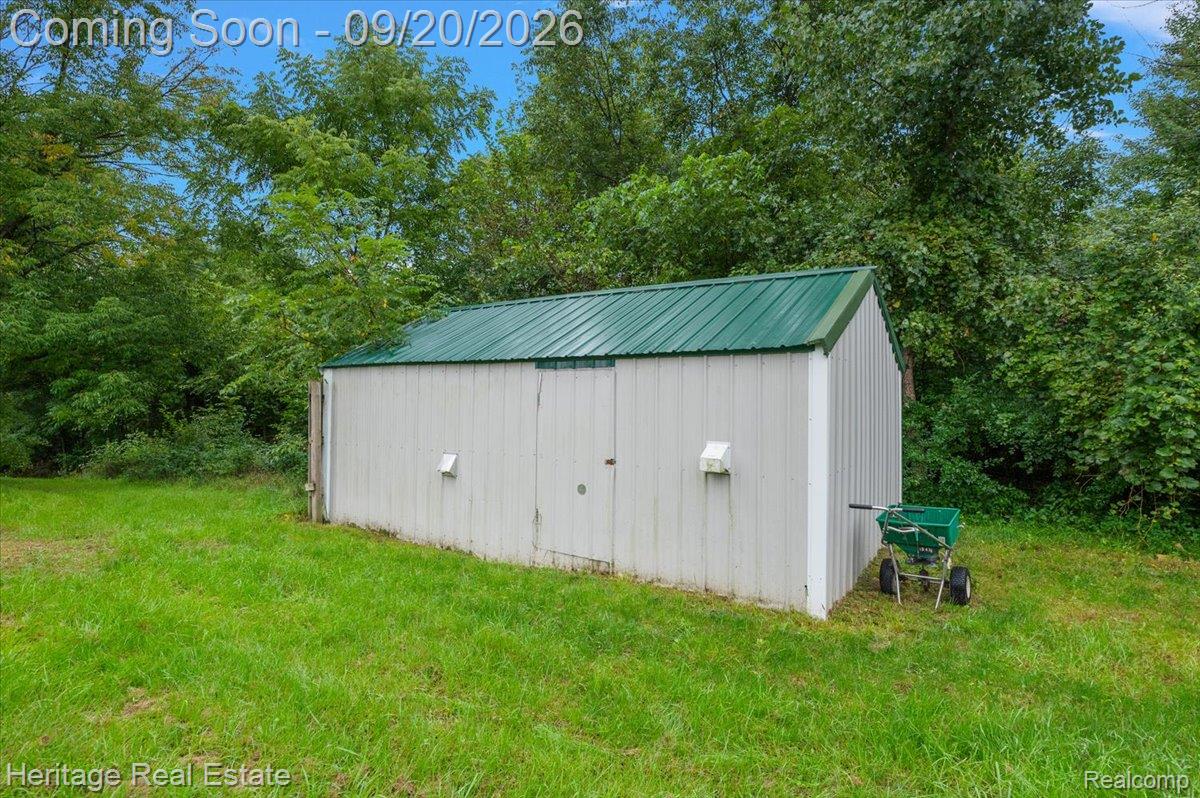 3337 Le Valley Road Columbiaville, MI 48421 - Photo 25 of 57 Detached storage shed featuring a green metal roof and a light-colored exterior