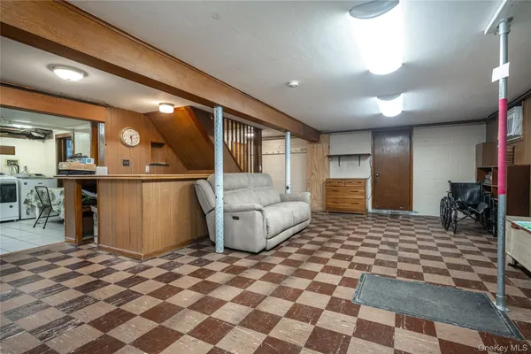 a living room with a black white checkered floor with couches chair and a coffee table