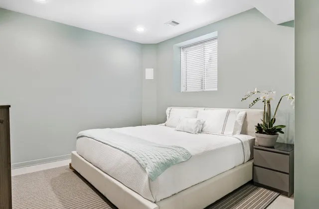 a view of a house with brick walls plants and large tree