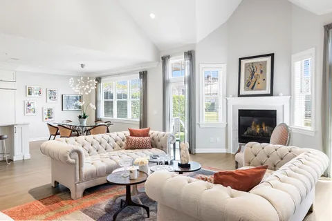a living room with furniture fireplace and a large window