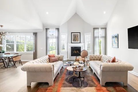 a dining room with wooden floor a chandelier a wooden table and chairs