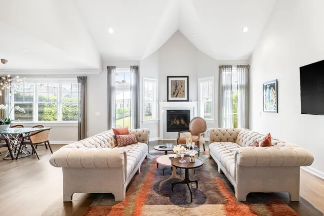 a dining room with wooden floor a chandelier a wooden table and chairs