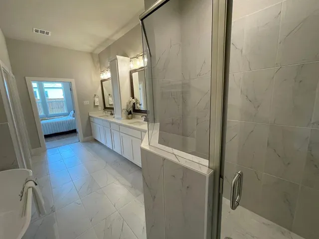 a bathroom with a tub a sink and mirrors