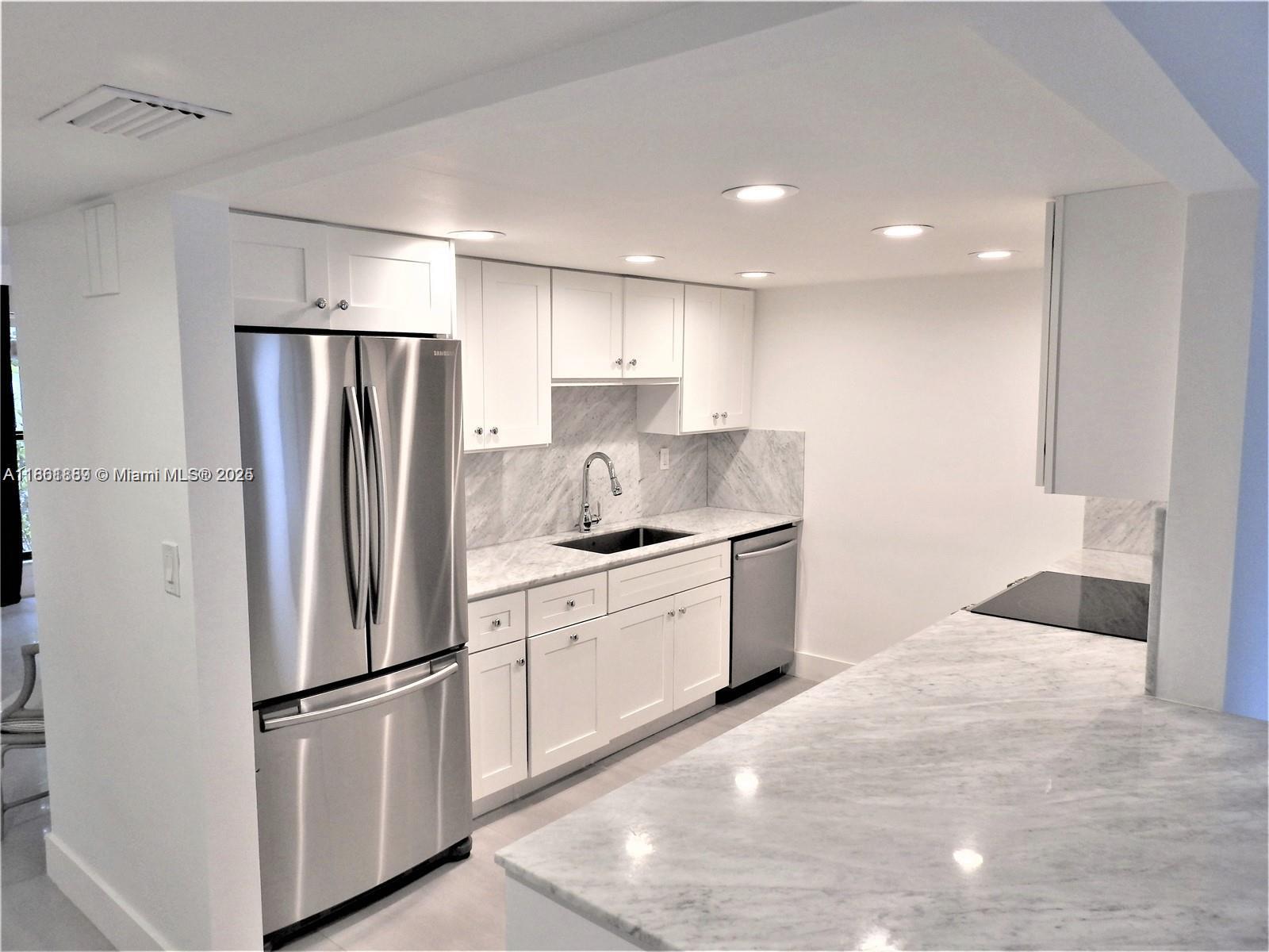 9807 Southwest 93rd Street, Unit 9807 Miami, FL 33176 - Photo 11 of 50 a kitchen with stainless steel appliances granite countertop a refrigerator sink and white cabinets