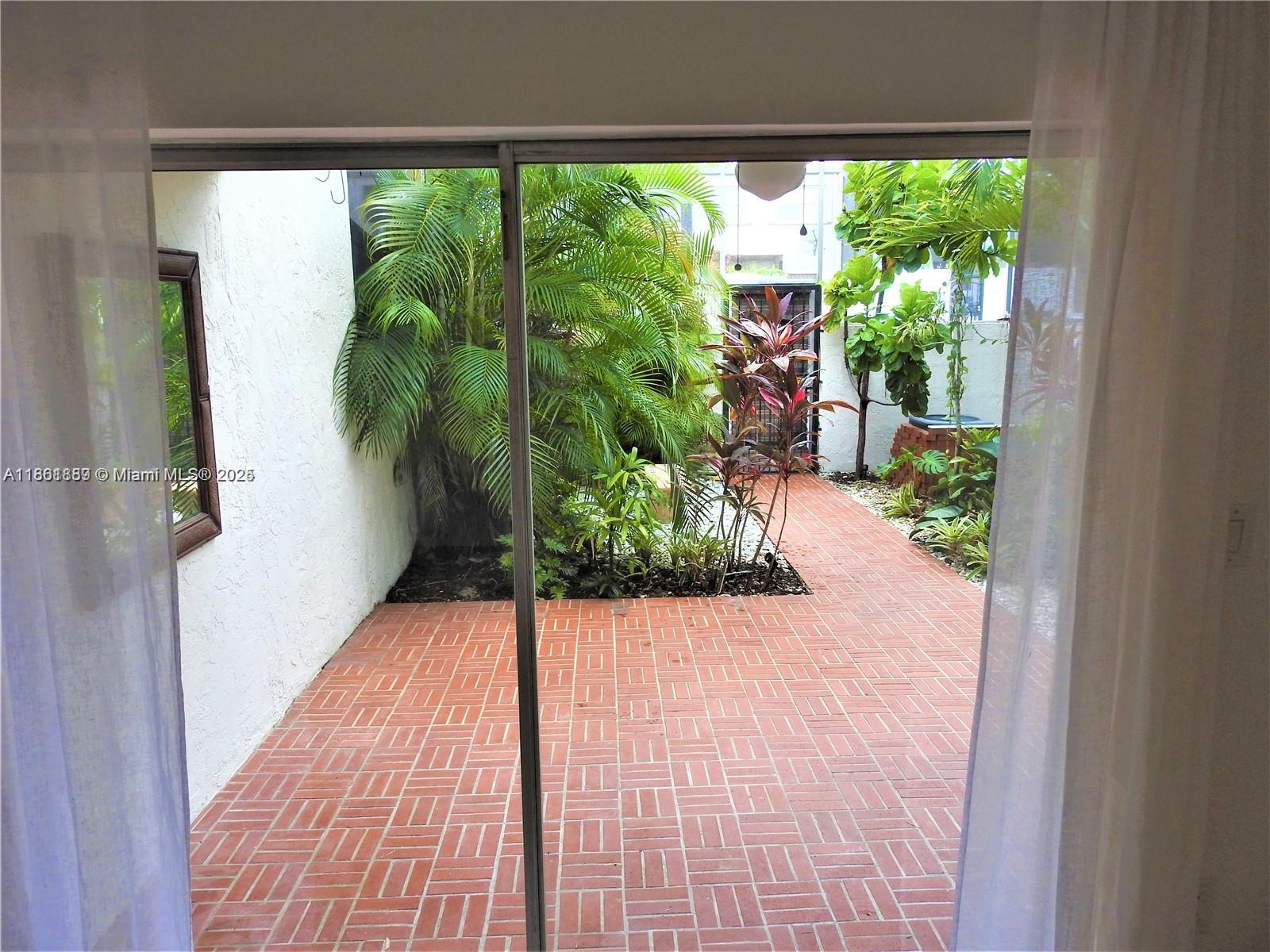 9807 Southwest 93rd Street, Unit 9807 Miami, FL 33176 - Photo 22 of 50 a view of potted plants with glass windows