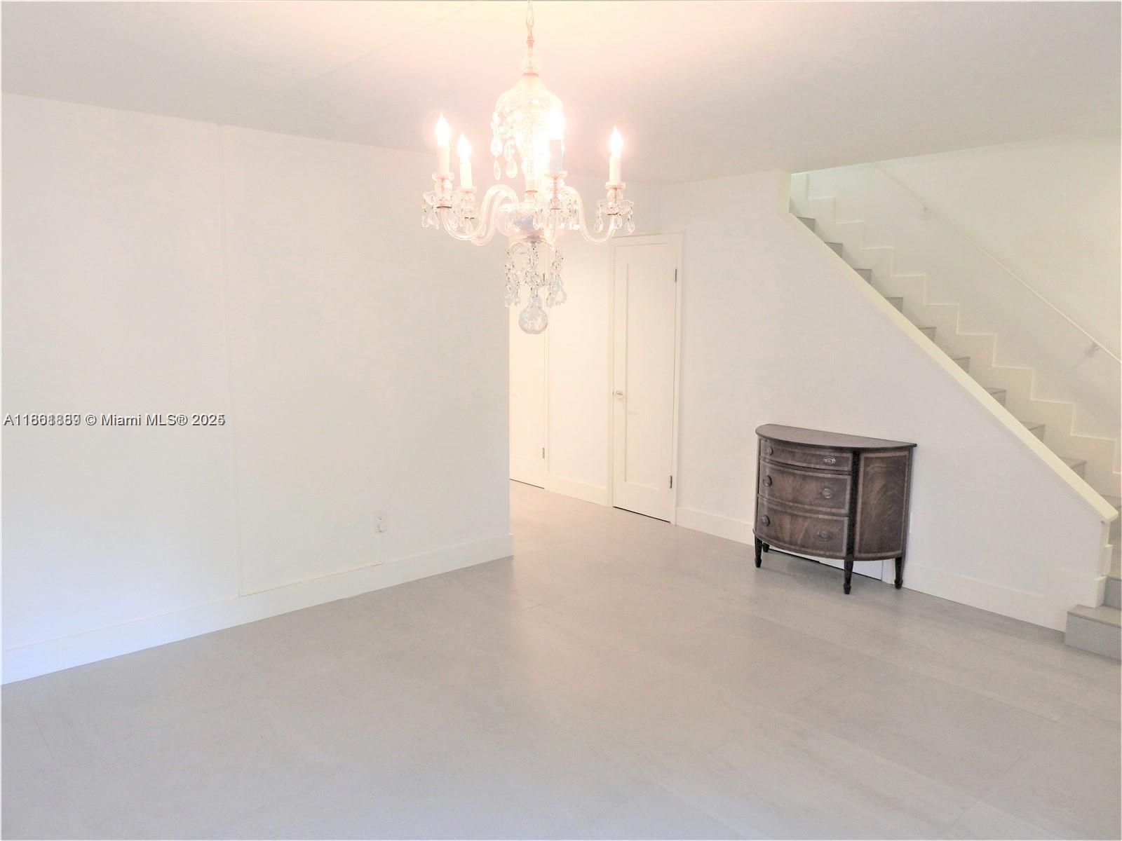 9807 Southwest 93rd Street, Unit 9807 Miami, FL 33176 - Photo 26 of 50 a view of a room with a chandelier fan and a window