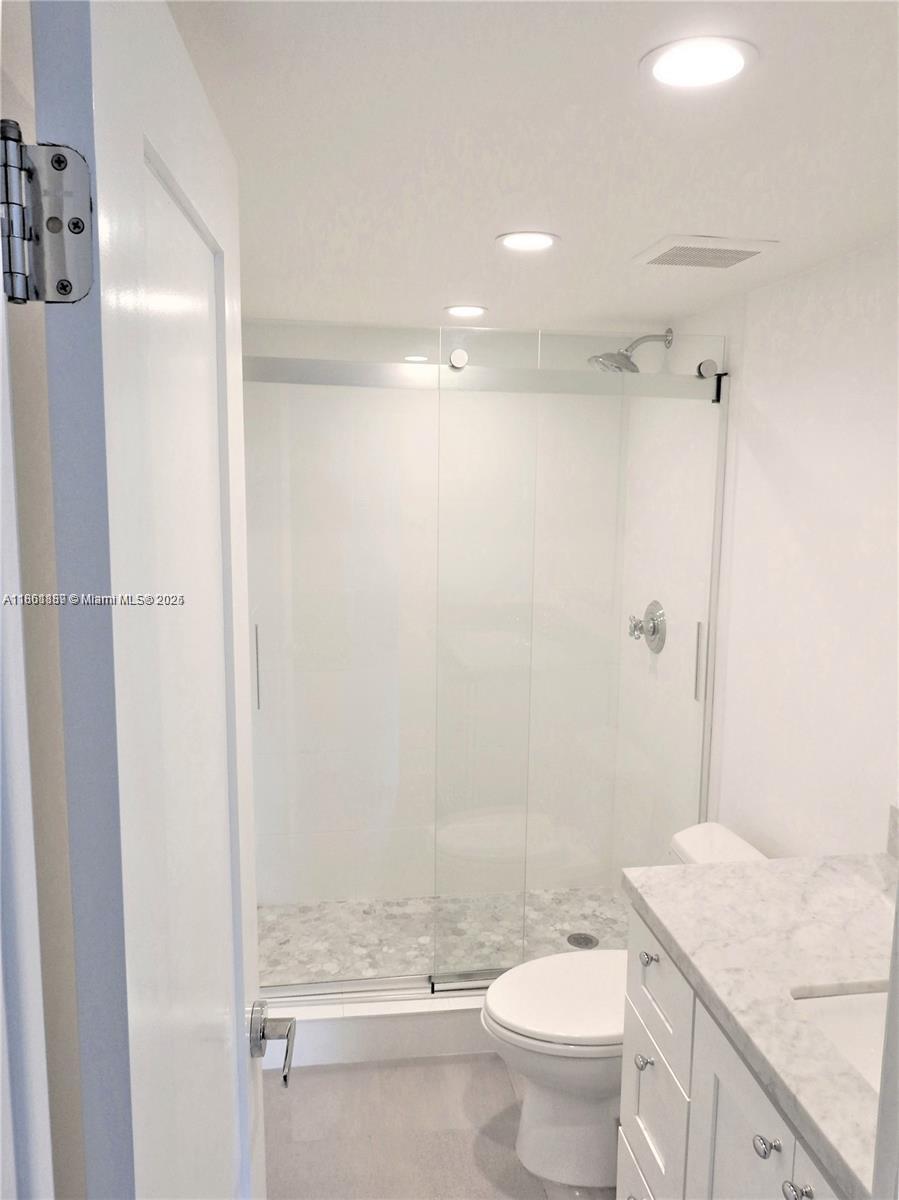 9807 Southwest 93rd Street, Unit 9807 Miami, FL 33176 - Photo 37 of 50 a bathroom with a granite countertop sink a toilet and shower