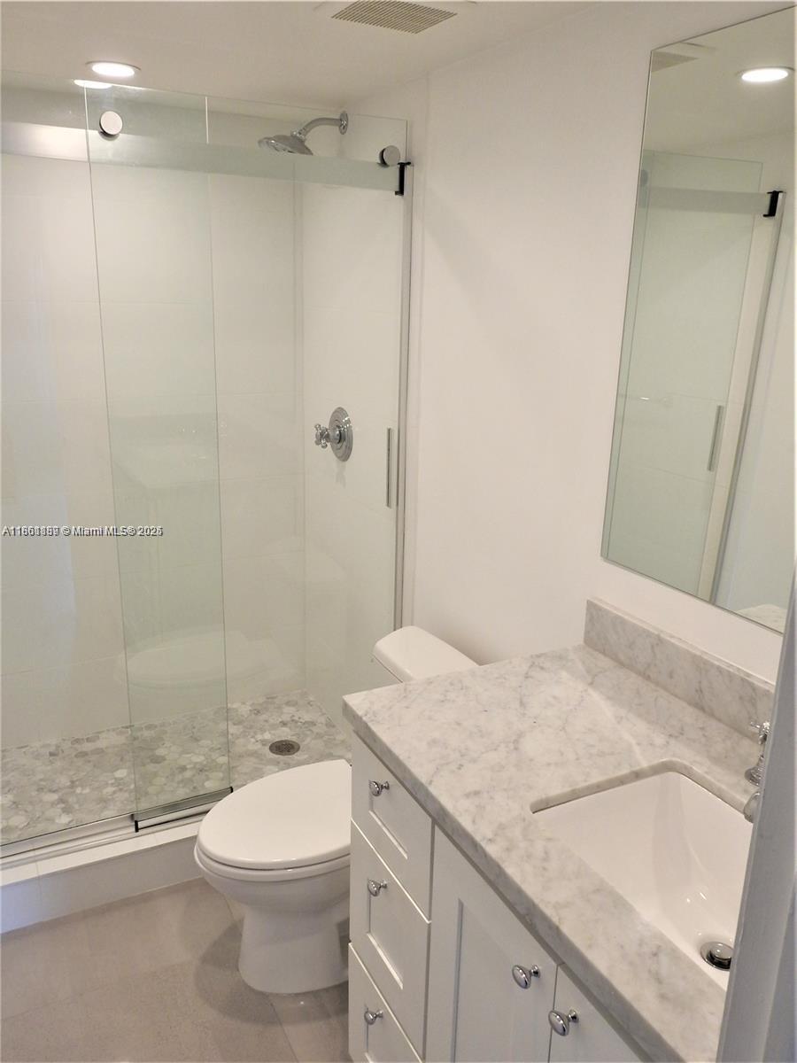 9807 Southwest 93rd Street, Unit 9807 Miami, FL 33176 - Photo 38 of 50 a bathroom with a granite countertop sink a toilet and shower