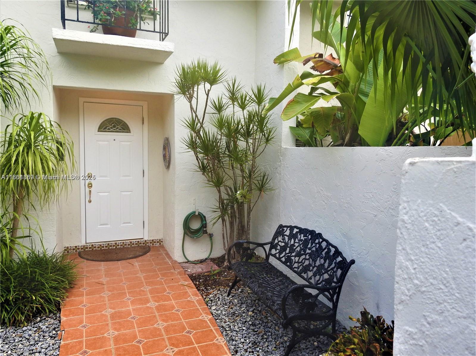 9807 Southwest 93rd Street, Unit 9807 Miami, FL 33176 - Photo 4 of 50 a vase of flowers sitting on a table with potted plant