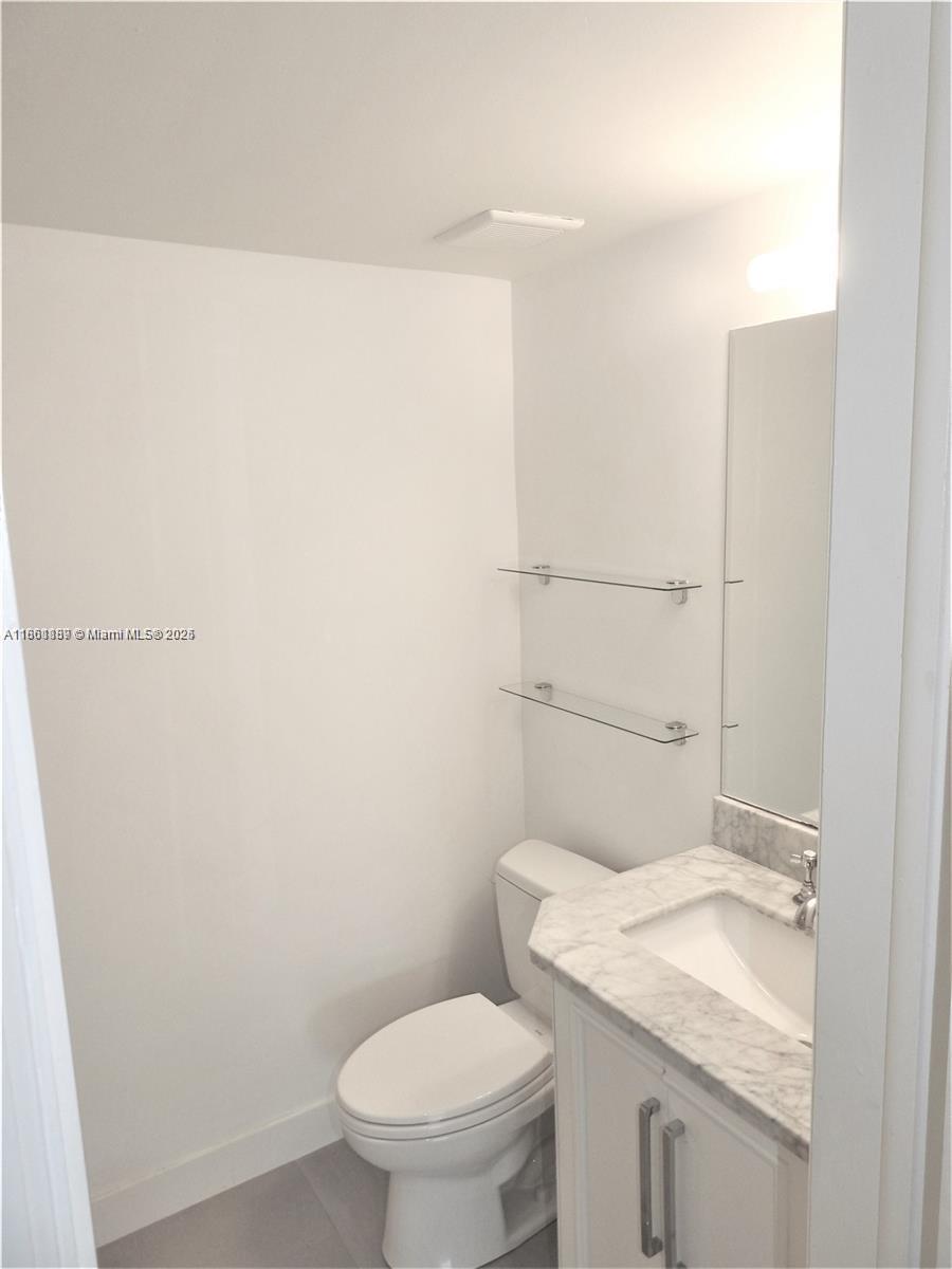 9807 Southwest 93rd Street, Unit 9807 Miami, FL 33176 - Photo 43 of 50 a bathroom with a granite countertop toilet and a sink