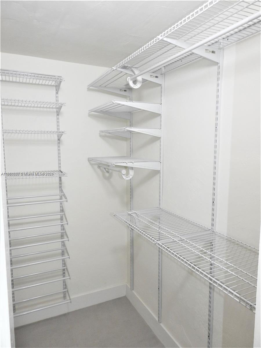 9807 Southwest 93rd Street, Unit 9807 Miami, FL 33176 - Photo 48 of 50 a view of walk in closet with empty racks