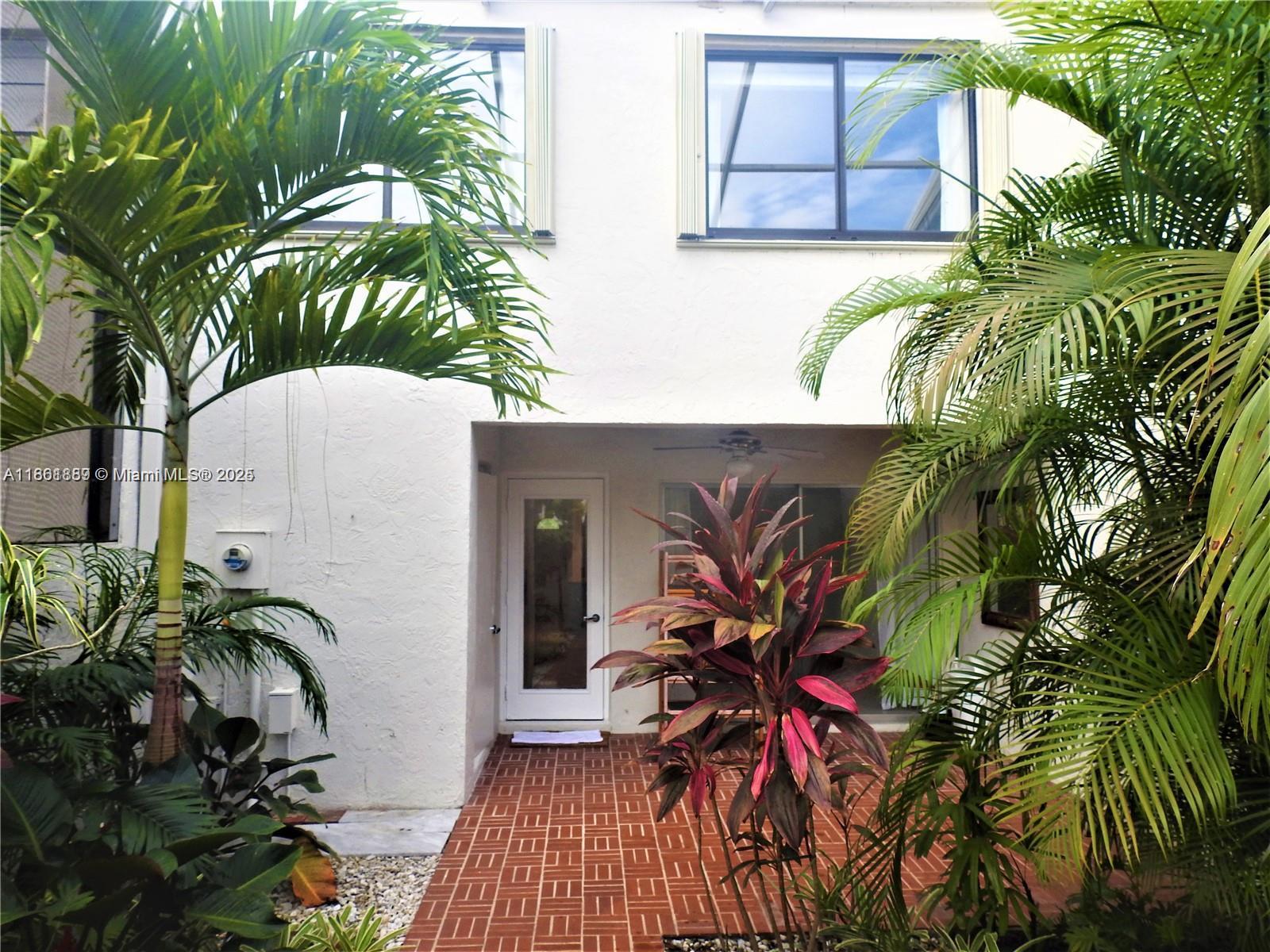 9807 Southwest 93rd Street, Unit 9807 Miami, FL 33176 - Photo 10 of 50 a view of a house with a potted plant and a large window