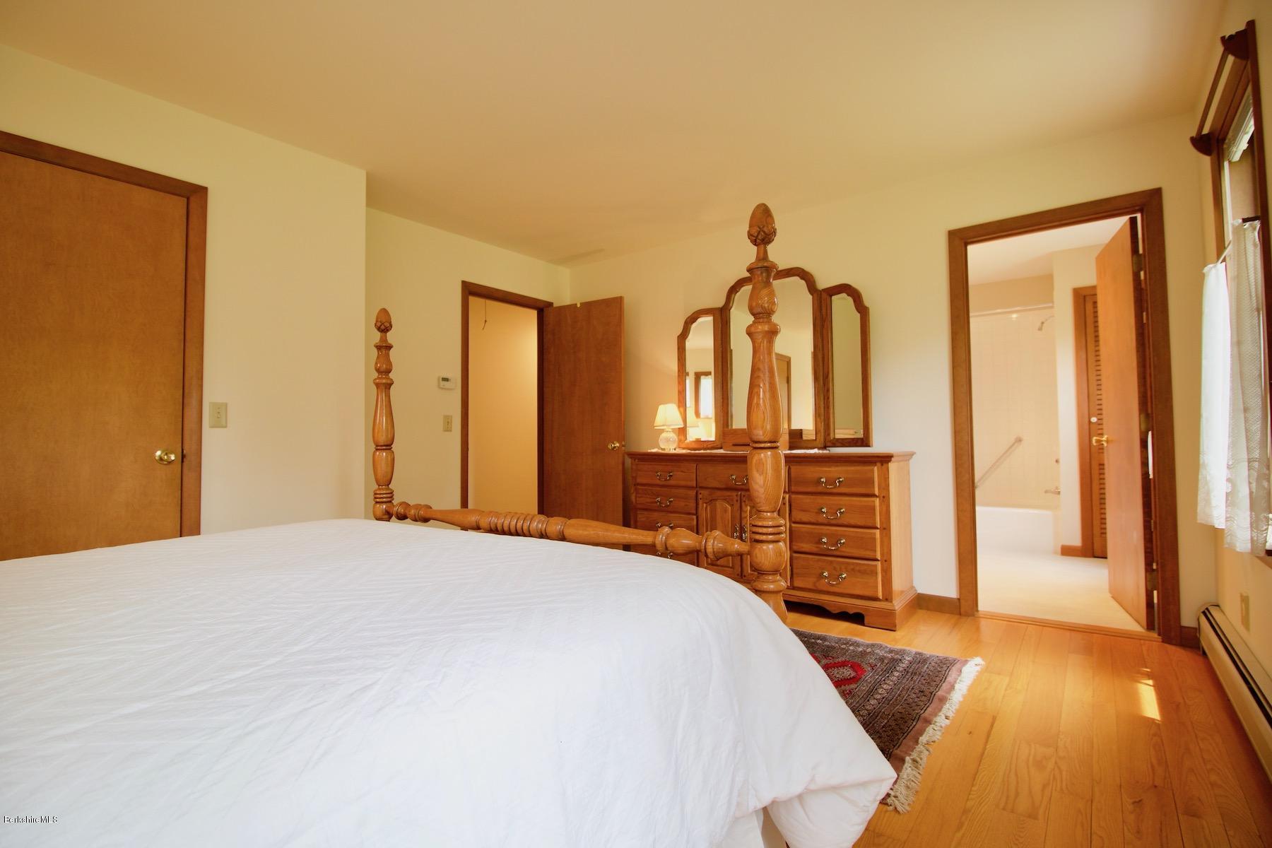22 Old Barn Road Lenox, MA 01240 - Photo 29 of 37 a bedroom with a bed and a chandelier