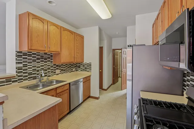 a kitchen with stainless steel appliances granite countertop a refrigerator and a sink