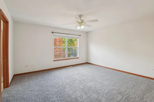 an empty room with a ceiling fan and a window