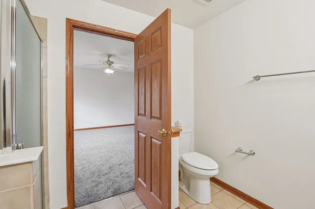 a bathroom with a granite countertop toilet and a shower