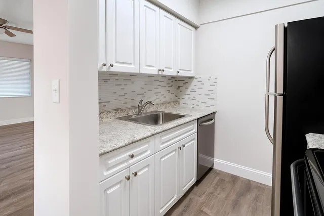 a kitchen with stainless steel appliances granite countertop a refrigerator and a sink