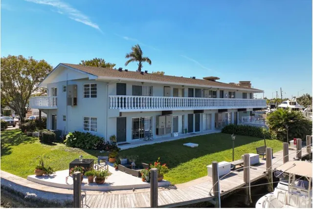 a view of a house with swimming pool lawn chairs and a yard