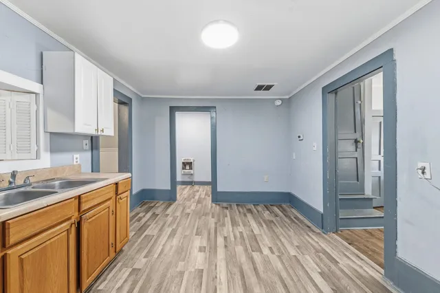 a kitchen with a sink and wooden floor