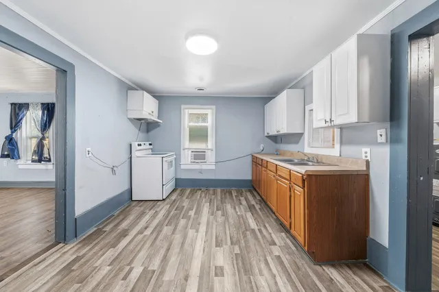 a kitchen with cabinets and wooden floor