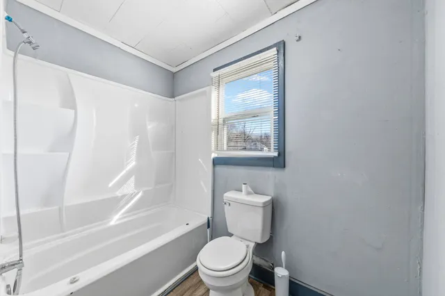 a white toilet sitting next to a bath tub shower