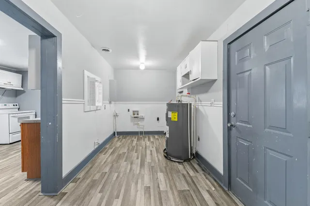 a view of a kitchen with a sink refrigerator and wooden floor