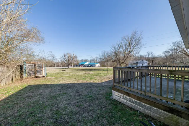 a view of a yard with wooden fence